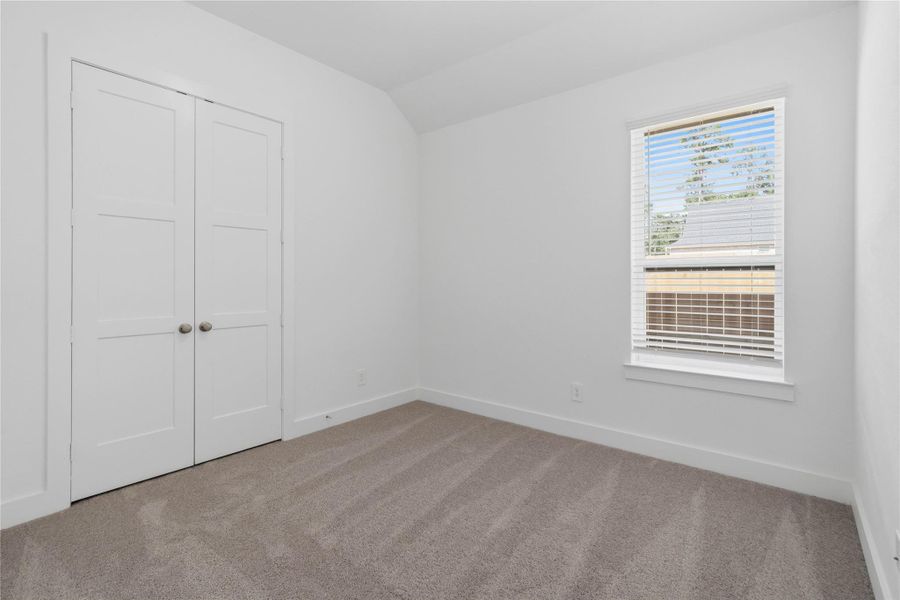 This cozy secondary bedroom offers plush soft carpeting, neutral walls ready for personalization, a sun-filled window with fitted blinds, sloped ceilings, and a spacious closet for all your storage needs. This cozy secondary bedroom offers plush soft carpeting, neutral walls ready for personalization, a sun-filled window with fitted blinds, sloped ceilings, and a spacious closet for all your storage needs.