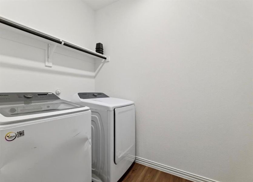 Laundry room featuring dark wood-type flooring and washer and clothes dryer