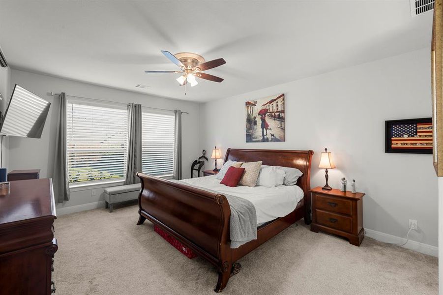 Bedroom featuring light colored carpet and ceiling fan Bedroom featuring light colored carpet and ceiling fan