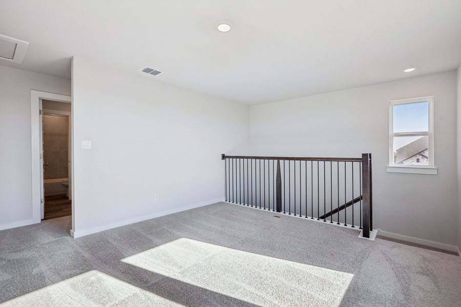 A room with a rug and a railing.