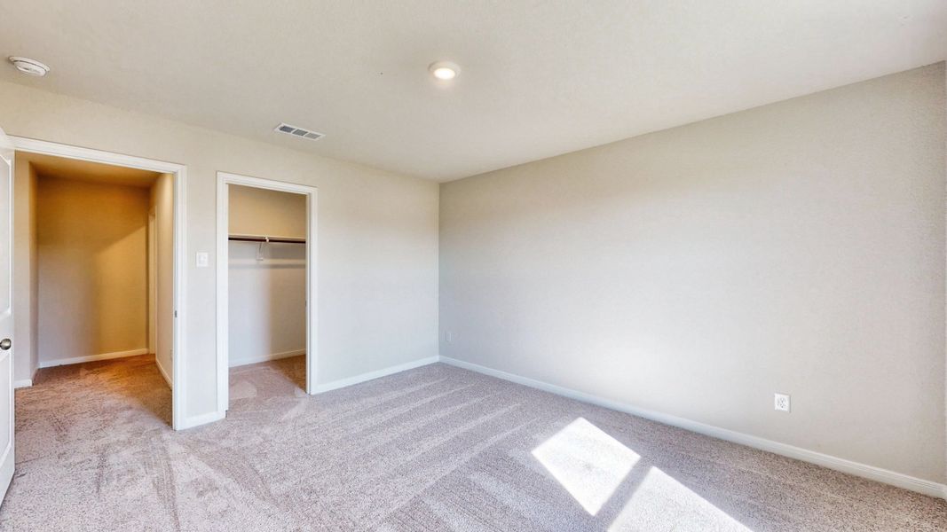 A room with a carpet and a door.