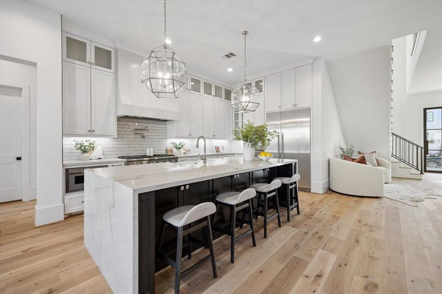 The centerpiece of the kitchen, a substantial center island, commands attention with its sheer size and is adorned by stunning pendant lights that not only illuminate the culinary stage but also add a touch of sophistication to the space.