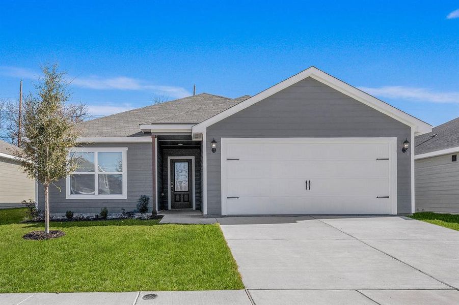 Single story home featuring a garage and a front lawn