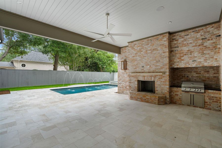 [Loggia / Summer Kitchen]Al fresco dining and conversation area in the loggia offers a brick fireplace and grill.