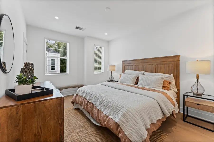 This spacious second-floor primary bedroom exudes modern elegance with its sleek engineered wood flooring that adds warmth and texture underfoot. Soaring high ceilings amplify the sense of openness, allowing natural light to cascade in and highlight the room’s architectural charm. Whether styled with minimalist furnishings or layered with cozy accents, the space offers a serene retreat elevated by its refined finishes and elevated vantage point.