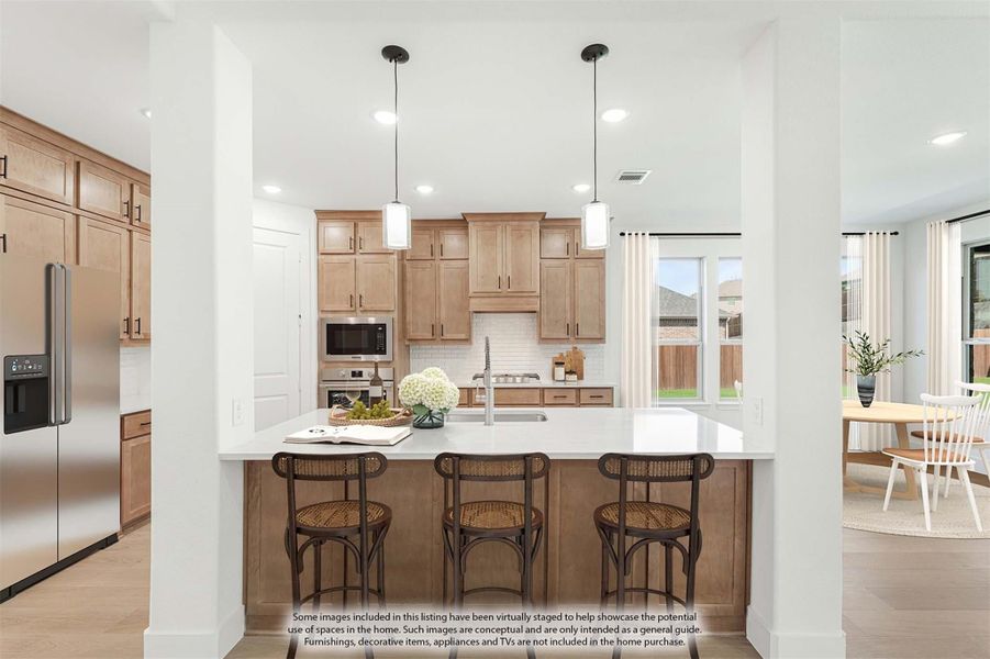 Kitchen with light wood cabinets, white island with bar seating, pendant lights, and stainless steel appliances Kitchen with light wood cabinets, white island with bar seating, pendant lights, and stainless steel appliances