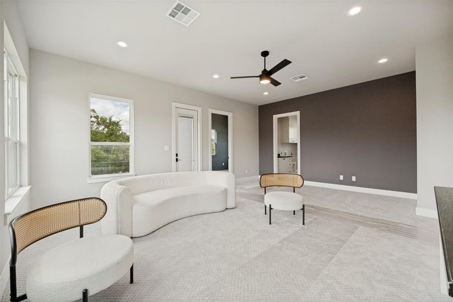 Recessed lighting and a ceiling fan illuminate this spacious loft with light-toned flooring. Recessed lighting and a ceiling fan illuminate this spacious loft with light-toned flooring.