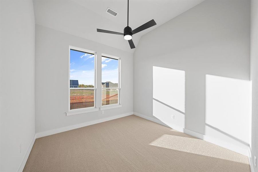 Empty room with lofted ceiling, light carpet, and ceiling fan Empty room with lofted ceiling, light carpet, and ceiling fan