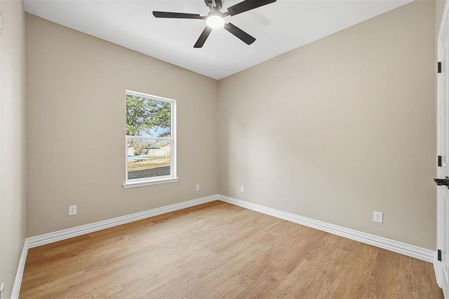 Empty room featuring light wood-style floors and ceiling fan Empty room featuring light wood-style floors and ceiling fan