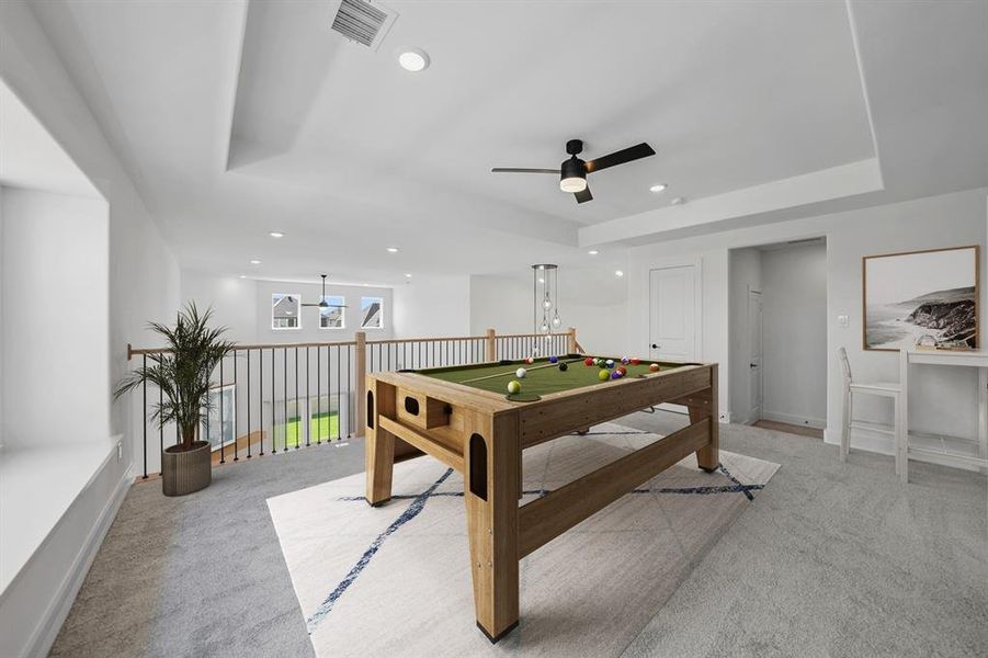 Recreation room with light carpet, a raised ceiling, recessed lighting, and a ceiling fan