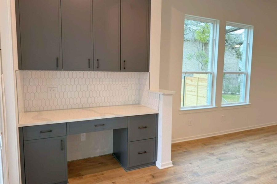 Unfurnished office featuring built in study area and light wood-style flooring
