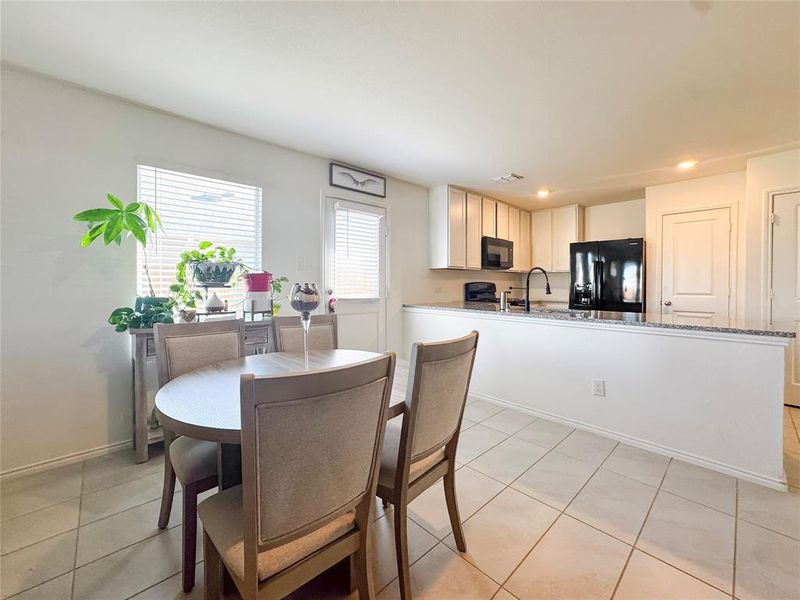 Dining area with light tile patterned floors and recessed lighting