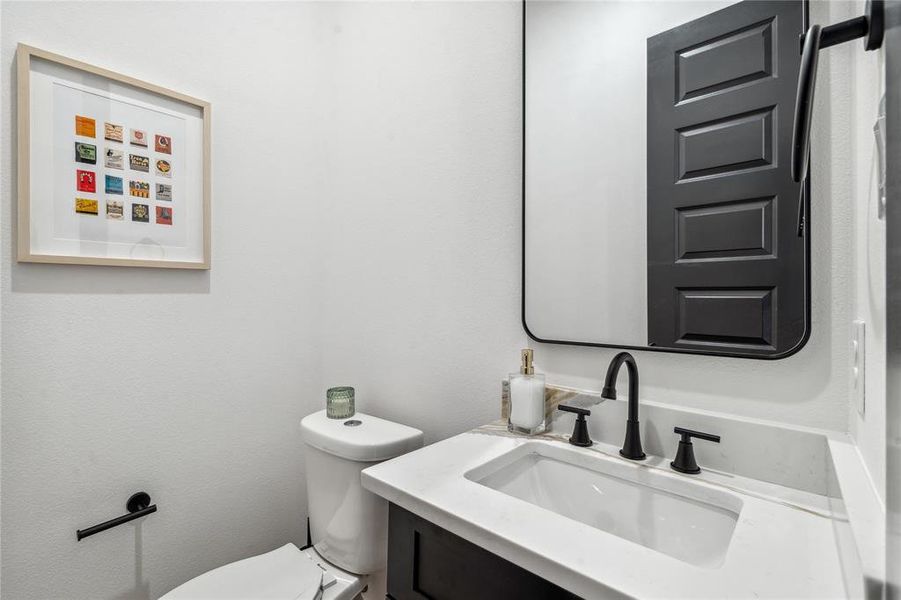 Featuring sleek modern fixtures and a simple, clean design, this half bathroom offers a chic and functional space for guests