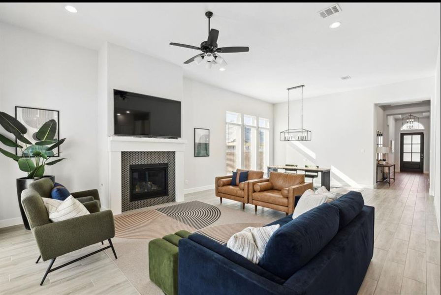 Living room featuring light wood finished floors, a tile fireplace, recessed lighting, and a ceiling fan