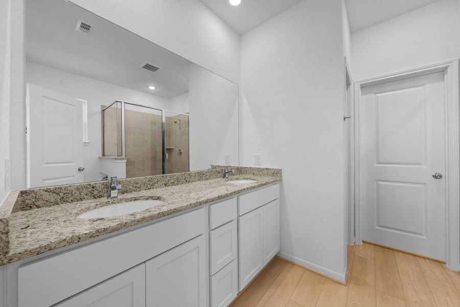 Primary bathroom has dual sinks and granite countertops