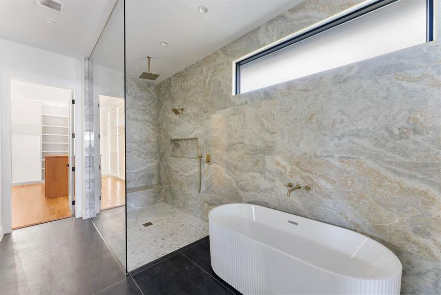 Full bath with a soaking tub, a marble finish shower, a spacious closet, and tile patterned floors Full bath with a soaking tub, a marble finish shower, a spacious closet, and tile patterned floors