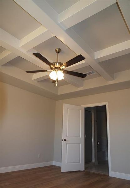 Spare room with ceiling fan, dark hardwood / wood-style floors, and beam ceiling