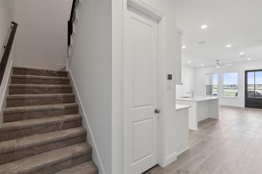 You'll find the stairs leading to the second level located across from your spacious walk in pantry!