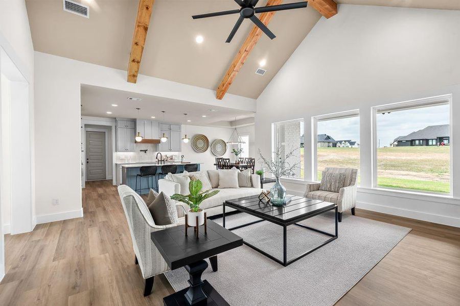 Living area with high vaulted ceiling, recessed lighting, beamed ceiling, light wood-style flooring, and a ceiling fan Living area with high vaulted ceiling, recessed lighting, beamed ceiling, light wood-style flooring, and a ceiling fan