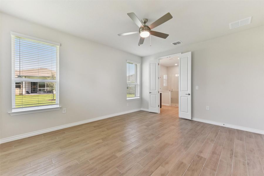 Spare room featuring light wood-type flooring and a ceiling fan Spare room featuring light wood-type flooring and a ceiling fan