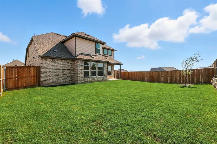 Rear view of house featuring a fenced backyard, a patio, a shingled roof, and brick siding Rear view of house featuring a fenced backyard, a patio, a shingled roof, and brick siding