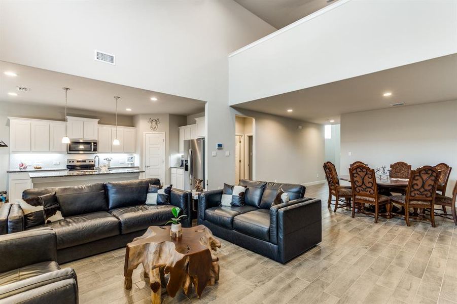 Living room featuring light hardwood / wood-style floors and a high ceiling