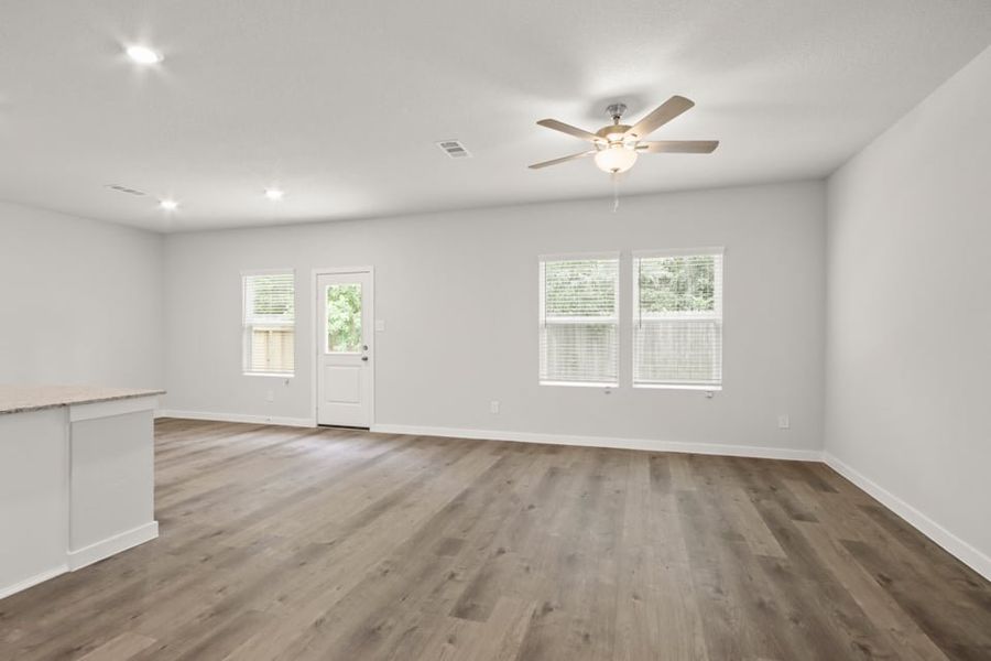 A room with a ceiling fan and a wood floor. A room with a ceiling fan and a wood floor.