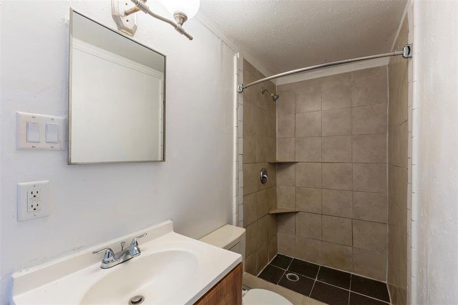Bathroom with a shower stall, vanity, and a textured ceiling Bathroom with a shower stall, vanity, and a textured ceiling