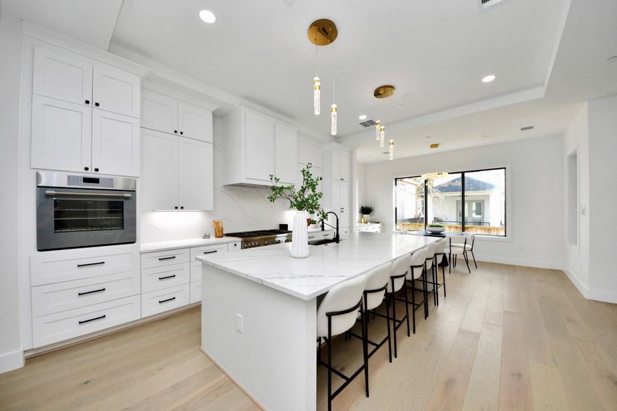 From the dramatic 11-foot island to the high-end appliances and luminous lighting, every detail of this kitchen is curated to deliver a seamless balance of sophistication and practicality.