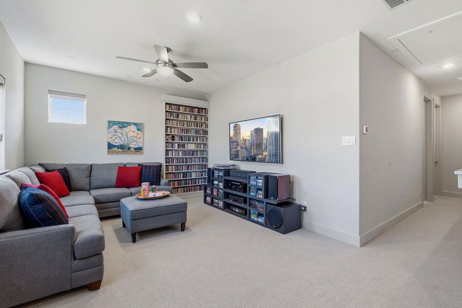 Living room with light colored carpet and a ceiling fan Living room with light colored carpet and a ceiling fan