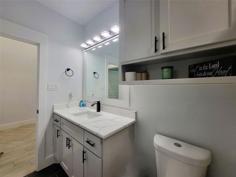 Hall Bathroom featuring vanity and parquet flooring