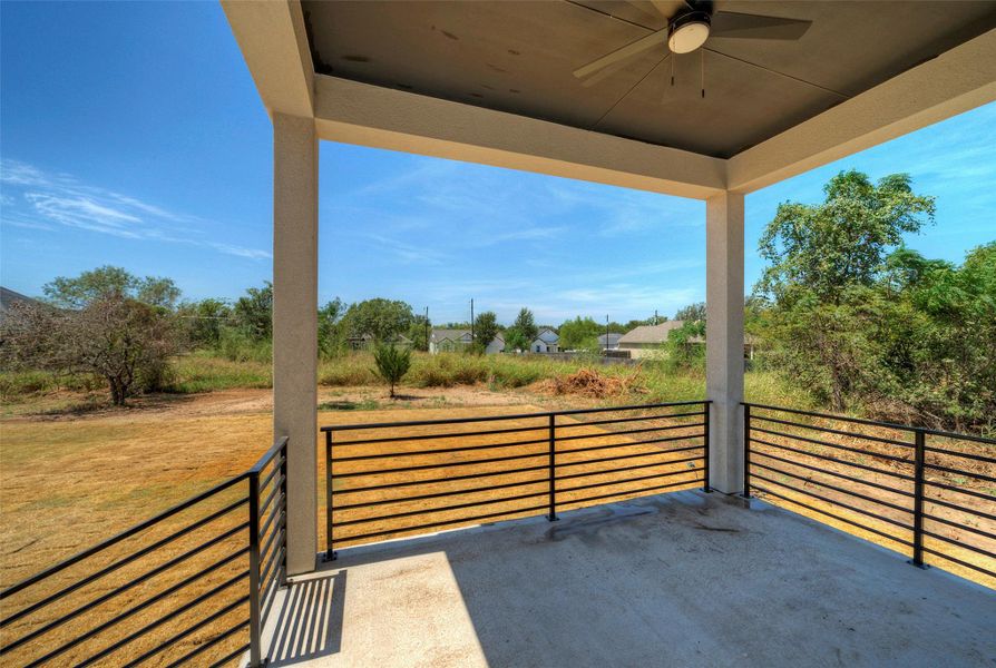 A covered back porch overlooks a grassy yard framed by mature trees. A covered back porch overlooks a grassy yard framed by mature trees.