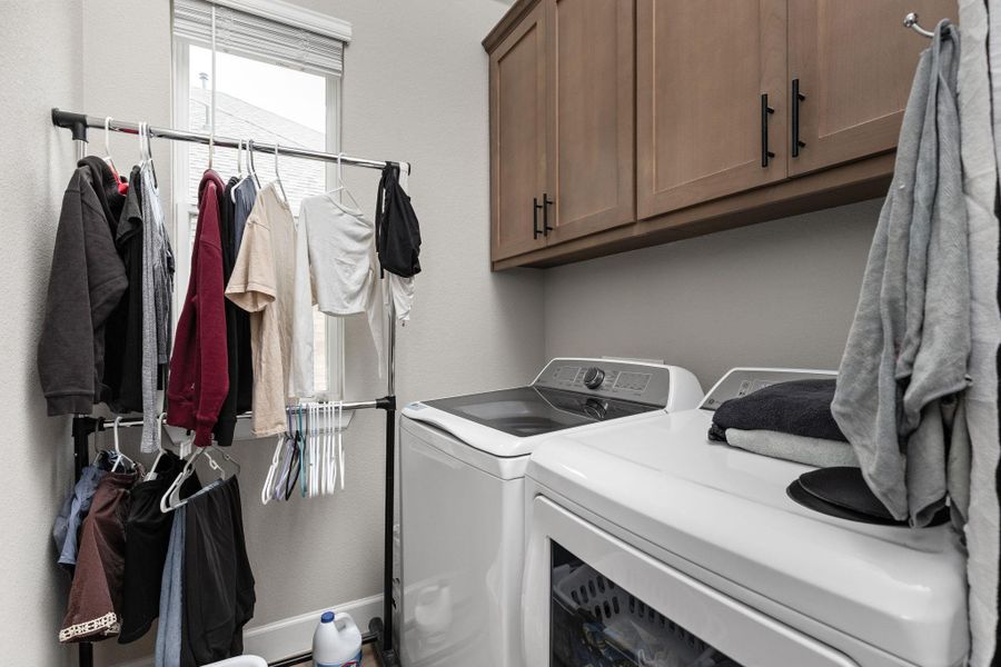 Laundry area with independent washer and dryer and cabinet space