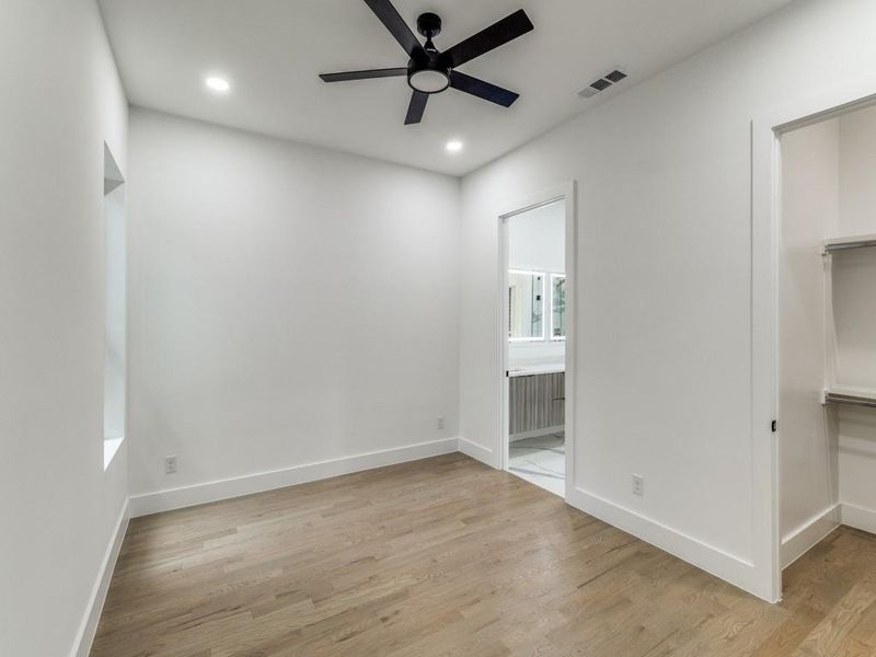 Unfurnished bedroom featuring a walk in closet, light wood-type flooring, recessed lighting, a closet, and ensuite bath