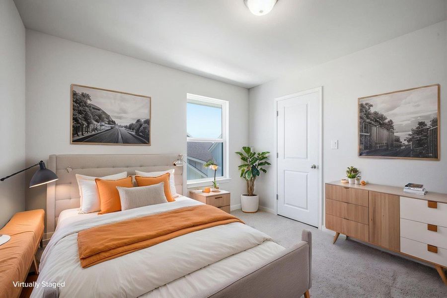 Natural light streams through a large window onto soft carpeting in this welcoming bedroom. Natural light streams through a large window onto soft carpeting in this welcoming bedroom.