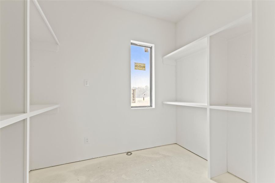 Spacious closet with built-in shelving, ample storage, and a large window for natural light