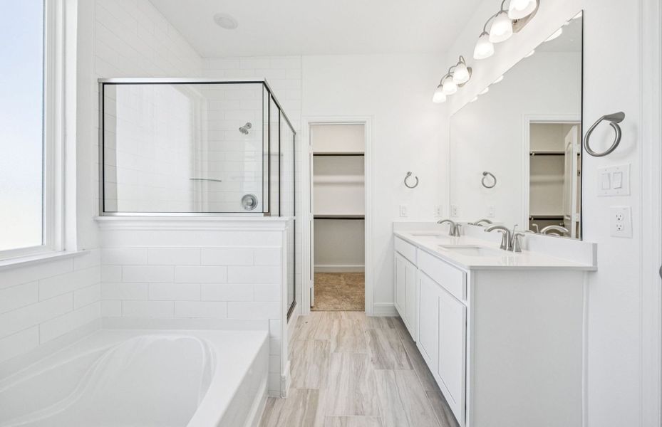 Spacious owner's suite with oversized shower and tub *real home pictured