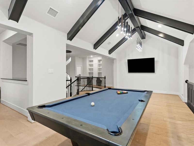 Vaulted ceiling featuring exposed beams and modern linear chandeliers Vaulted ceiling featuring exposed beams and modern linear chandeliers