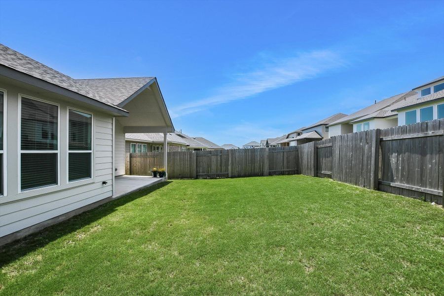 Expansive backyard featuring a manicured lawn, full irrigation, and privacy fencing