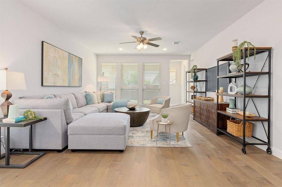 Living room with light hardwood floors and ceiling fan