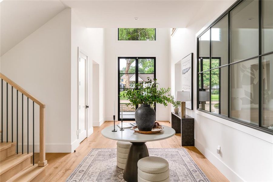 Foyer entrance with plenty of natural light, light wood finished floors, and stairs
