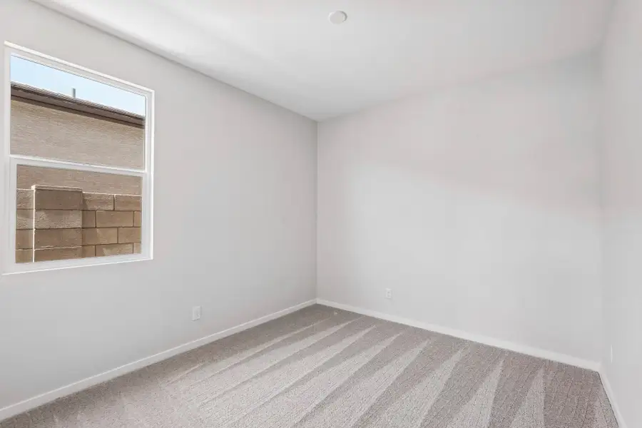 A room with a window and a rug.