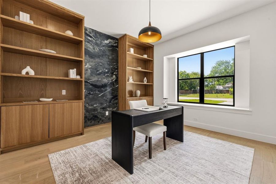 Room featuring built-in wood shelving, a dark accent wall, and wood-finish flooring