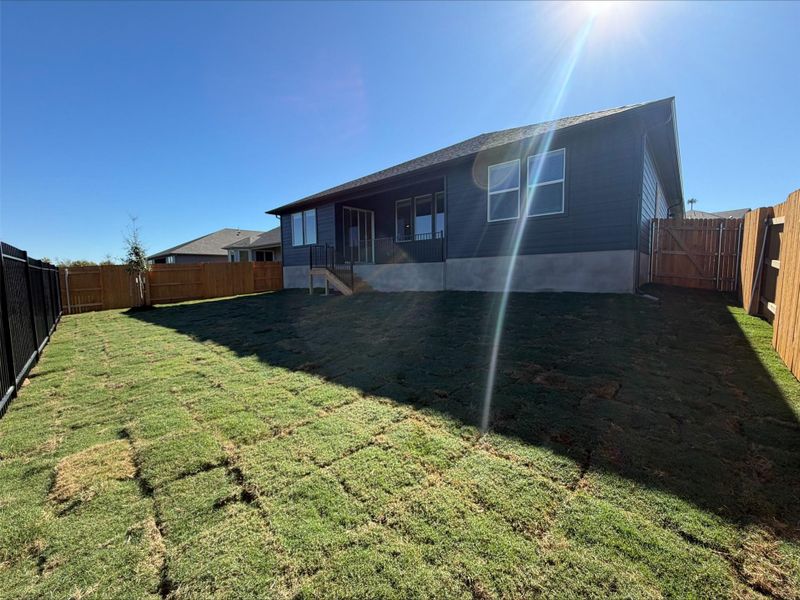 Rear view of property with a fenced backyard and a gate