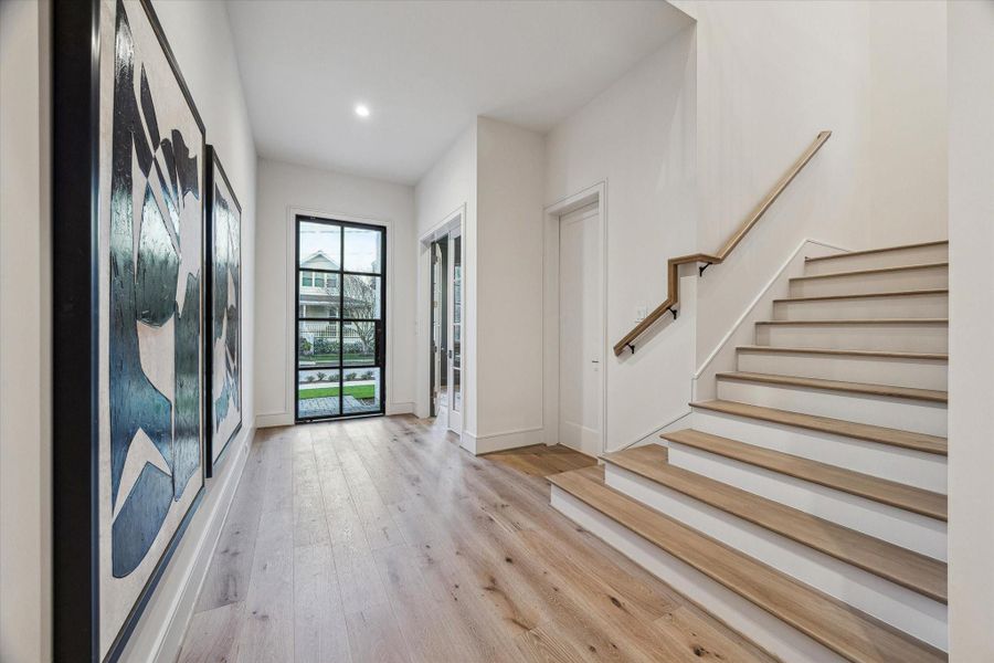 A massive entry welcomes guests to true luxury. High ceilings and hardwoods are in unfaltering quantities here. The glass door floods the space with sunlight for a welcoming atmosphere. A sleek staircase is complete with white oak treads and railing.