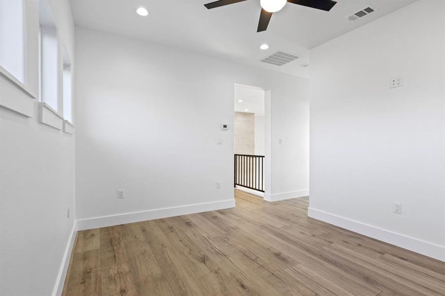 Unfurnished room featuring light wood-style floors, ceiling fan, baseboards, and visible vents Unfurnished room featuring light wood-style floors, ceiling fan, baseboards, and visible vents