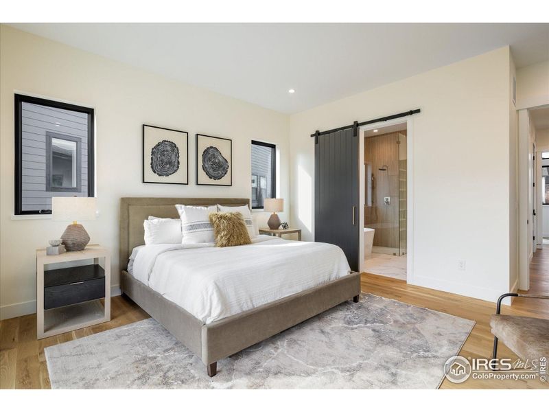 Main floor primary suite includes this beautiful custom barn door entry to a truly fabulous bathroom and closet, including washer/dryer hookups!