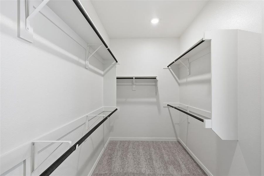 Walk in closet featuring light carpet Walk in closet featuring light carpet