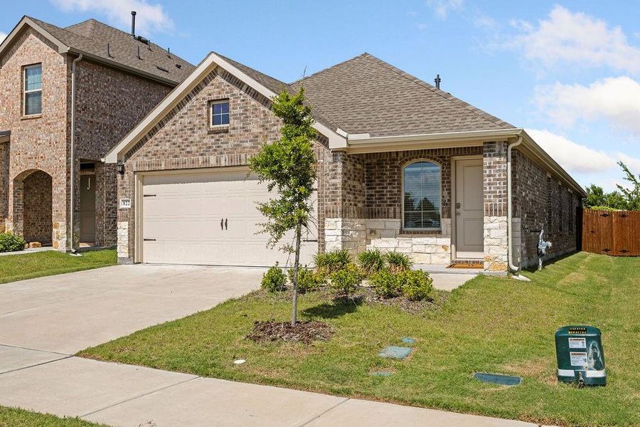Brick and stone exterior featuring an attached two-car garage Brick and stone exterior featuring an attached two-car garage