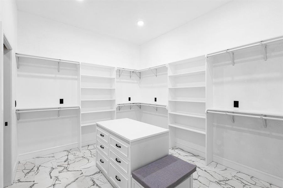 Walk in closet featuring light marble finish floors